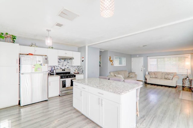 17152 Schollview Ave, Palmdale, CA 93591 - kitchen with freestanding refrigerator, gas stove, a center island, and white cabinetry