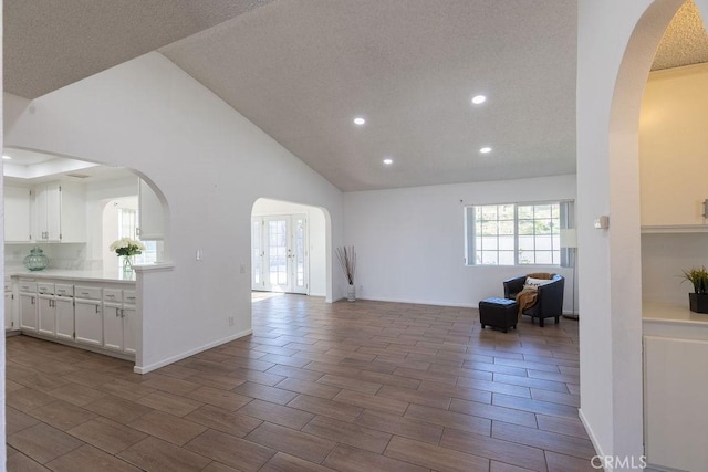 42117 Agena St, Temecula, CA 92592 - unfurnished living room featuring recessed lighting, arched walkways, wood finish floors, high vaulted ceiling, and baseboards
