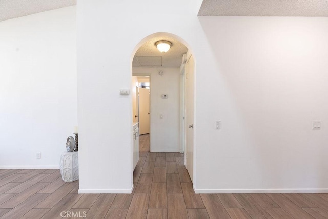 42117 Agena St, Temecula, CA 92592 - corridor featuring arched walkways, wood finished floors, and baseboards
