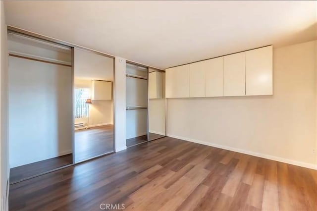 1105 Sepulveda Blvd # C101, Torrance, CA 90502 - unfurnished bedroom with dark wood finished floors, baseboards, and a baseboard radiator