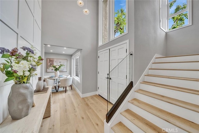 10 Lassen, Irvine, CA 92612 - entryway featuring stairway, light wood-type flooring, baseboards, and a towering ceiling