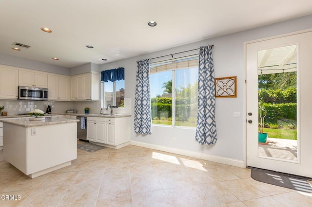 904 Calle Higuera, Camarillo, CA 93010 - kitchen featuring stainless steel appliances, white cabinets, a kitchen island, light tile patterned flooring, and baseboards