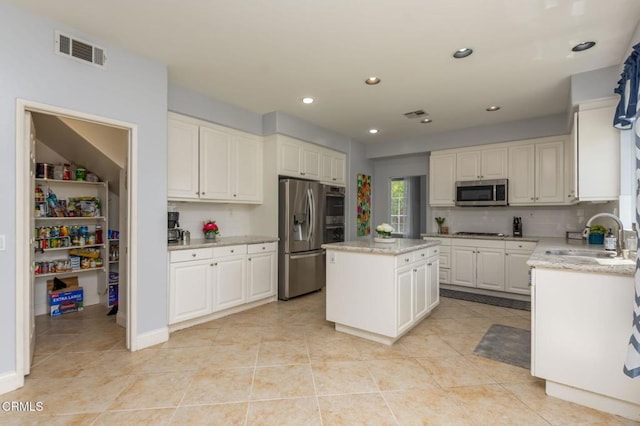 904 Calle Higuera, Camarillo, CA 93010 - kitchen featuring a sink, stainless steel appliances, a kitchen island, light tile patterned floors, and light stone counters