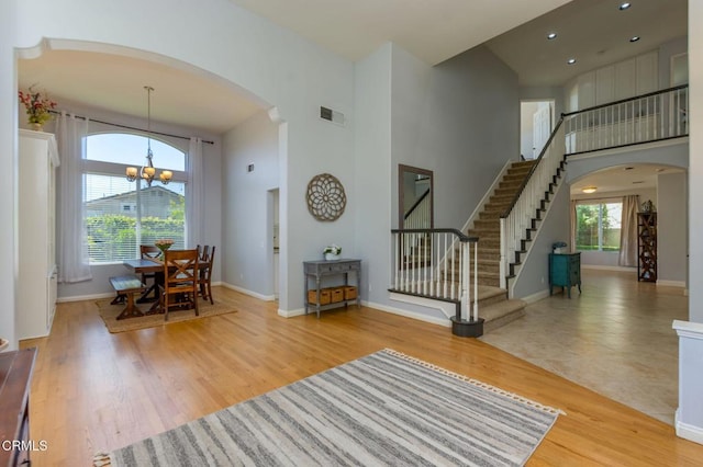 904 Calle Higuera, Camarillo, CA 93010 - living room featuring arched walkways, a towering ceiling, stairs, a chandelier, and baseboards
