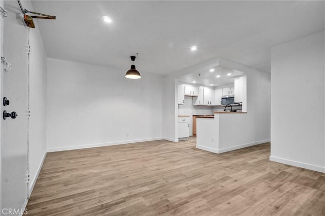 700 W 3rd St Unit A117, Santa Ana, CA 92701 - unfurnished living room with recessed lighting, light wood finished floors, and baseboards
