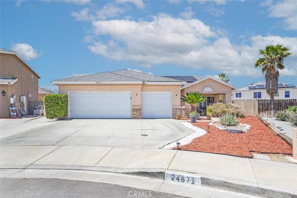 24871 Loire Ct, Hemet, CA 92544 - ranch-style home with stucco siding, concrete driveway, solar panels, a garage, and stone siding