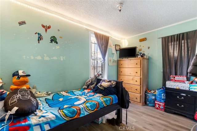 151 E 105th St, Los Angeles, CA 90003 - bedroom featuring a textured ceiling and wood finished floors