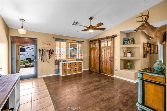 5115 Warren Vista Ave, Yucca Valley, CA 92284 - entrance foyer with a barn door, ceiling fan, vaulted ceiling, wood finished floors, and baseboards