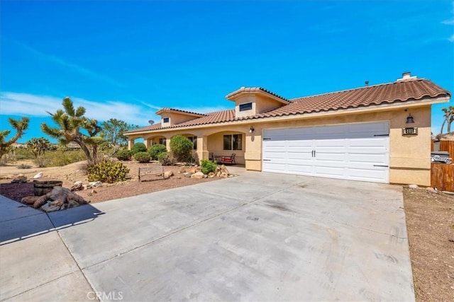 5115 Warren Vista Ave, Yucca Valley, CA 92284 - mediterranean / spanish home with driveway, a garage, stucco siding, and a tile roof