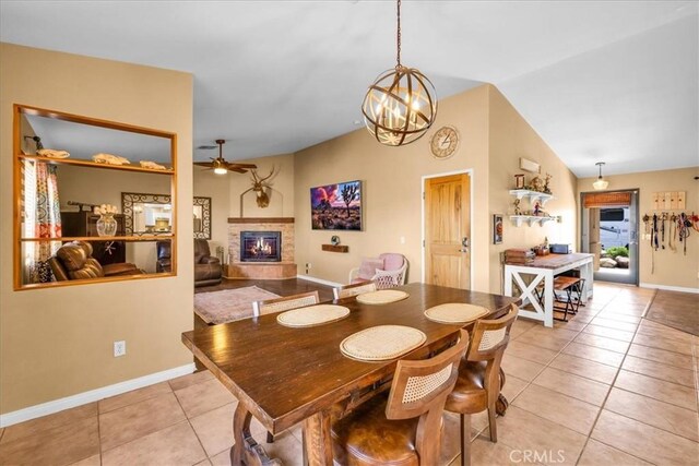 5115 Warren Vista Ave, Yucca Valley, CA 92284 - dining room featuring a glass covered fireplace, light tile patterned floors, a ceiling fan, baseboards, and a chandelier