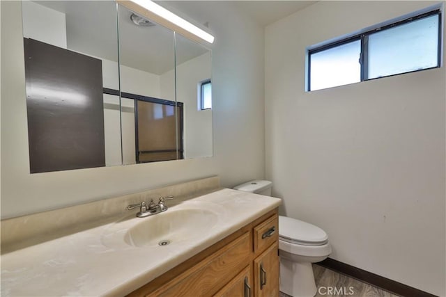 968 Lausanne Dr, Crestline, CA 92325 - bathroom with toilet, wood finished floors, vanity, and baseboards