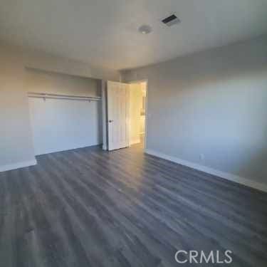 58922 Sunway Dr, Yucca Valley, CA 92284 - unfurnished bedroom with wood finished floors, baseboards, and a closet