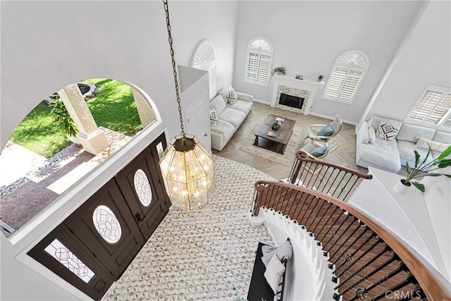 1048 Gladstone St, La Verne, CA 91750 - living room with a towering ceiling, baseboards, a fireplace, and a chandelier