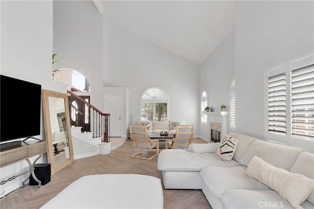 1048 Gladstone St, La Verne, CA 91750 - living room featuring high vaulted ceiling, stairs, a glass covered fireplace, and baseboards