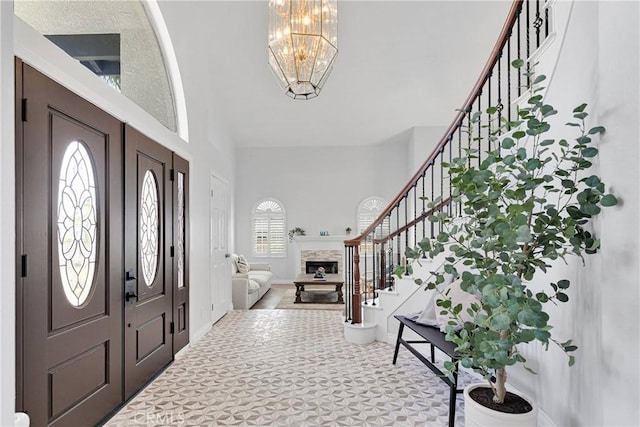 1048 Gladstone St, La Verne, CA 91750 - carpeted entryway with stairway, a chandelier, a fireplace, and a high ceiling