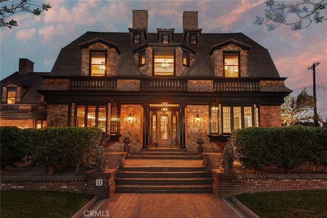 11 La Linda Dr, Long Beach, CA 90807 - back of property at dusk featuring a balcony and a chimney