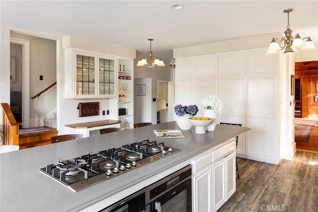 11 La Linda Dr, Long Beach, CA 90807 - kitchen with a chandelier, stainless steel gas cooktop, white cabinets, dark wood-style flooring, and decorative light fixtures