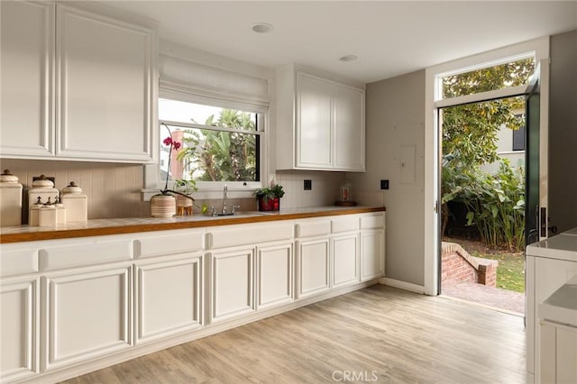 11 La Linda Dr, Long Beach, CA 90807 - kitchen with decorative backsplash, white cabinetry, light wood-style floors, and a sink