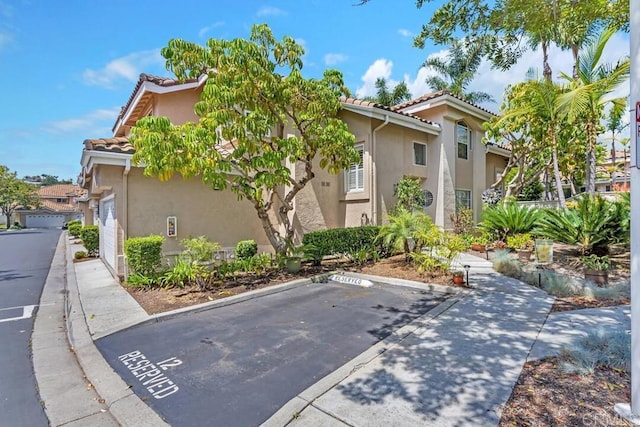 1873 Key Largo Rd, Vista, CA 92081 - view of home's exterior featuring stucco siding, a tiled roof, and uncovered parking