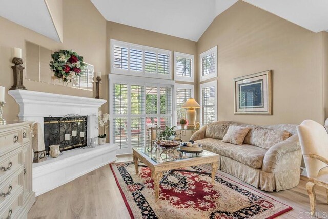 1873 Key Largo Rd, Vista, CA 92081 - living room featuring high vaulted ceiling, light wood-style floors, and a fireplace with raised hearth