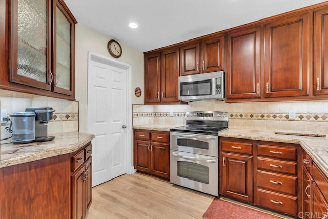 1873 Key Largo Rd, Vista, CA 92081 - kitchen featuring appliances with stainless steel finishes, light stone countertops, tasteful backsplash, and recessed lighting