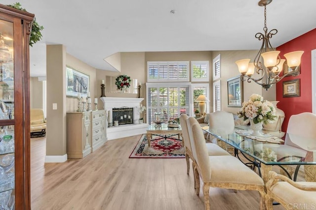 1873 Key Largo Rd, Vista, CA 92081 - dining area with a chandelier, light wood-style flooring, plenty of natural light, and a fireplace with raised hearth