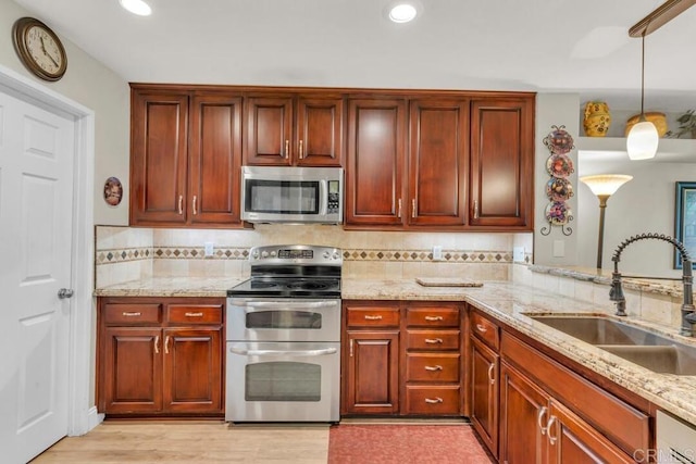 1873 Key Largo Rd, Vista, CA 92081 - kitchen featuring appliances with stainless steel finishes, a sink, light stone counters, hanging light fixtures, and recessed lighting