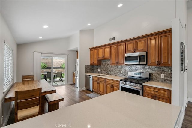 26882 Ayamonte, Mission Viejo, CA 92692 - kitchen with appliances with stainless steel finishes, a sink, vaulted ceiling, backsplash, and light countertops