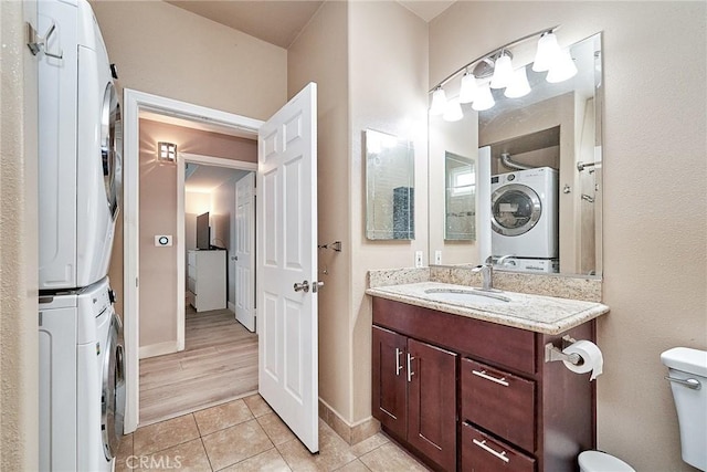 300 E Providencia Ave Unit 211, Burbank, CA 91502 - bathroom with stacked washer / dryer, vanity, tile patterned floors, toilet, and baseboards