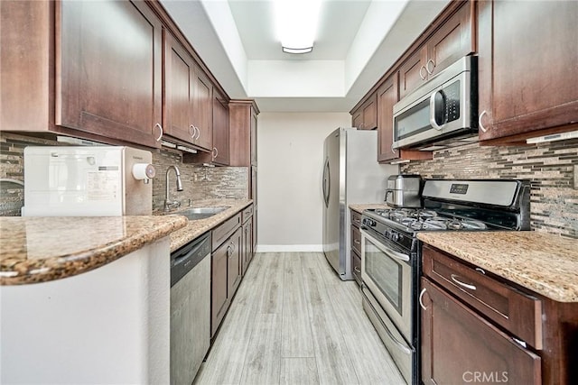 300 E Providencia Ave Unit 211, Burbank, CA 91502 - kitchen with stainless steel appliances, a sink, backsplash, light wood finished floors, and light stone countertops