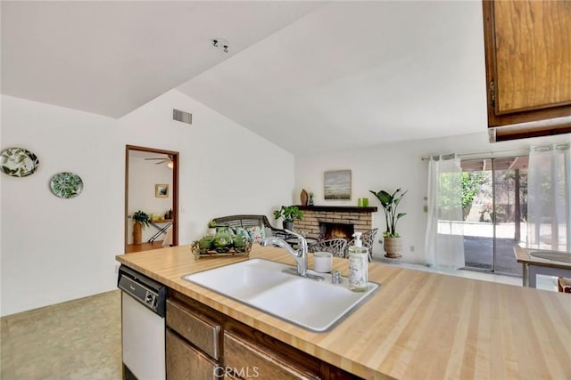 30124 Casa Chata Pl, Temecula, CA 92592 - kitchen featuring white dishwasher, a sink, vaulted ceiling, a brick fireplace, and butcher block countertops
