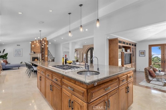 364 Via Almar, Palos Verdes Estates, CA 90274 - kitchen with open floor plan, a sink, stainless steel gas stovetop, brown cabinets, and a warm lit fireplace