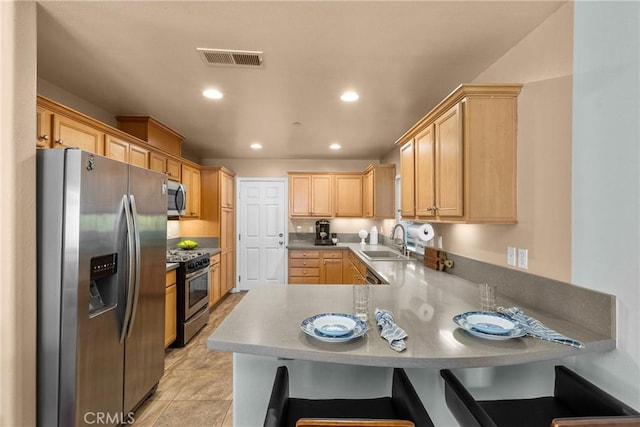 15721 Cobalt St Unit 118, Sylmar, CA 91342 - kitchen featuring stainless steel appliances, a peninsula, light brown cabinets, recessed lighting, and a kitchen bar
