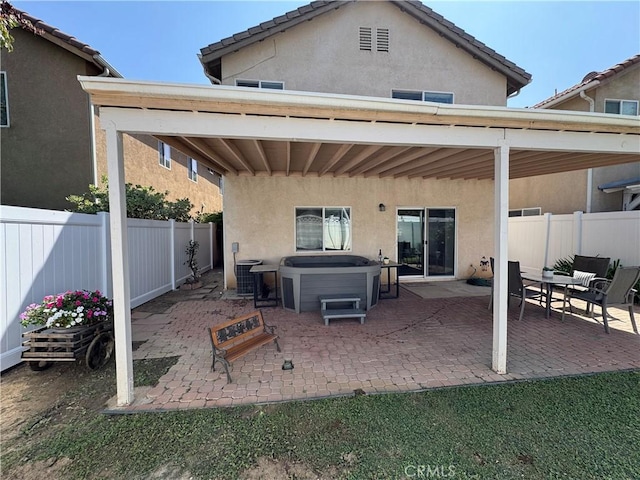 15721 Cobalt St Unit 118, Sylmar, CA 91342 - rear view of house featuring a hot tub, stucco siding, a fenced backyard, and a patio area