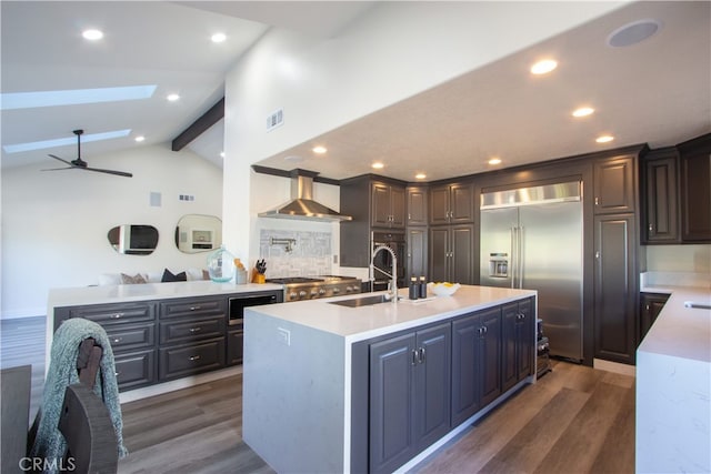 4374 Mahogany Cir, Yorba Linda, CA 92886 - kitchen featuring wall chimney exhaust hood, appliances with stainless steel finishes, dark wood-style flooring, a sink, and light countertops