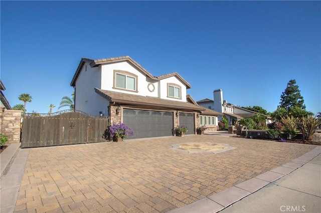4374 Mahogany Cir, Yorba Linda, CA 92886 - view of front of house with a garage, stucco siding, driveway, and a gate