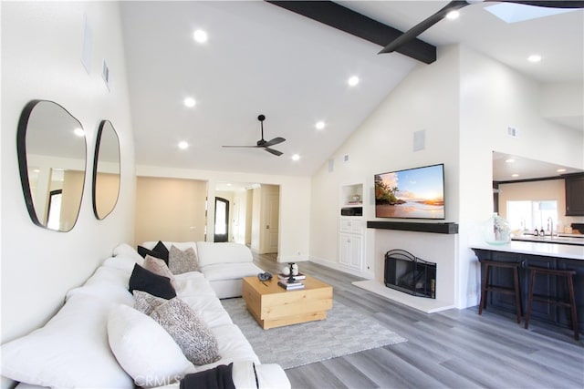 4374 Mahogany Cir, Yorba Linda, CA 92886 - living area with high vaulted ceiling, a ceiling fan, beamed ceiling, light wood-style floors, and a fireplace with raised hearth