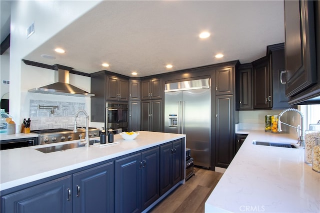 4374 Mahogany Cir, Yorba Linda, CA 92886 - kitchen with appliances with stainless steel finishes, a sink, wall chimney exhaust hood, tasteful backsplash, and dark wood-style flooring