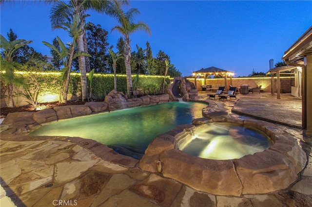 4374 Mahogany Cir, Yorba Linda, CA 92886 - pool at twilight with a fenced backyard, a water slide, a patio, a pool with connected hot tub, and a gazebo