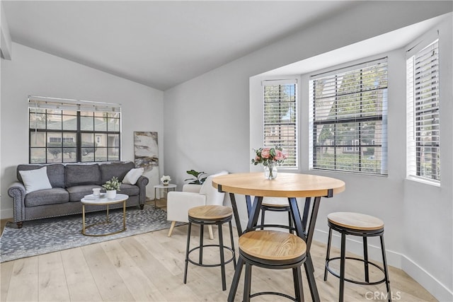 2633 Monte Carlo Unit 41, Santa Ana, CA 92706 - dining room featuring light wood-type flooring, vaulted ceiling, plenty of natural light, and baseboards