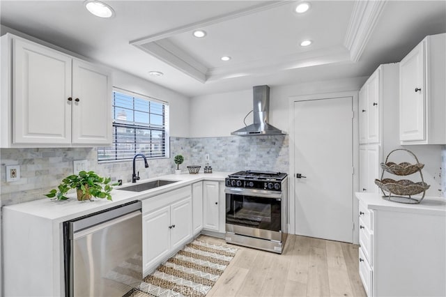2633 Monte Carlo Unit 41, Santa Ana, CA 92706 - kitchen with stainless steel appliances, wall chimney exhaust hood, a raised ceiling, a sink, and light wood finished floors