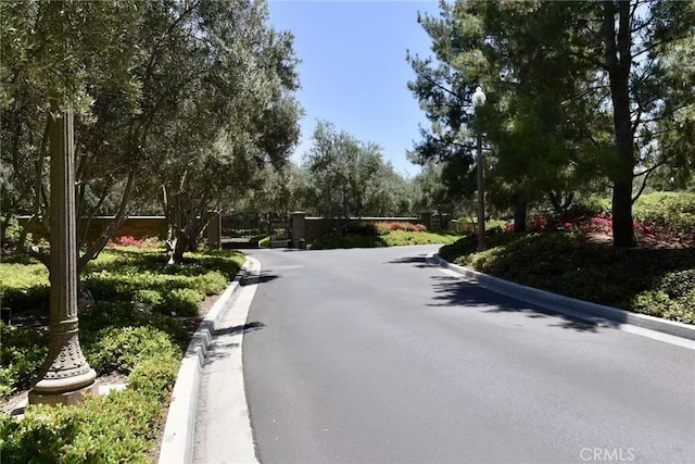 43 Lupari, Irvine, CA 92618 - view of asphalt road featuring curbs, a gate, and a gated entry