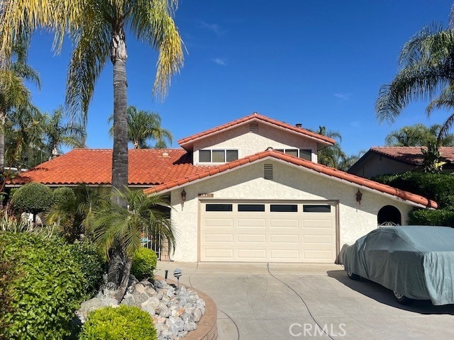 30417 Golden Gate Dr, Canyon Lake, CA 92587 - mediterranean / spanish house with a tiled roof, stucco siding, an attached garage, and driveway