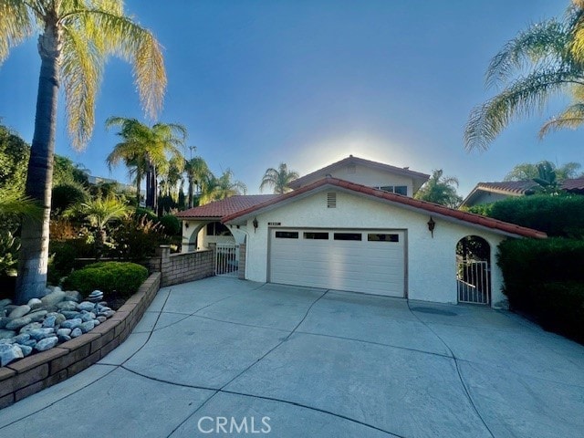 30417 Golden Gate Dr, Canyon Lake, CA 92587 - view of front facade featuring a garage, stucco siding, and driveway