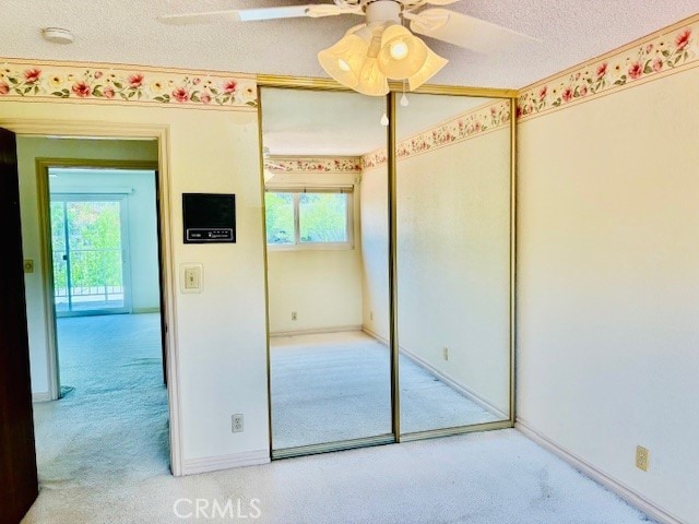 30417 Golden Gate Dr, Canyon Lake, CA 92587 - unfurnished bedroom with multiple windows, carpet floors, a textured ceiling, a closet, and a ceiling fan