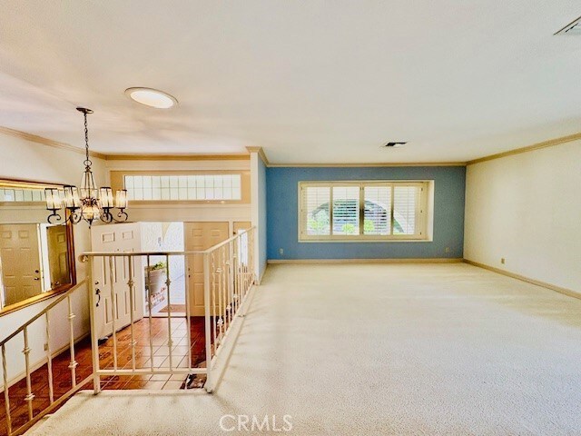 30417 Golden Gate Dr, Canyon Lake, CA 92587 - empty room featuring crown molding, a chandelier, and carpet floors