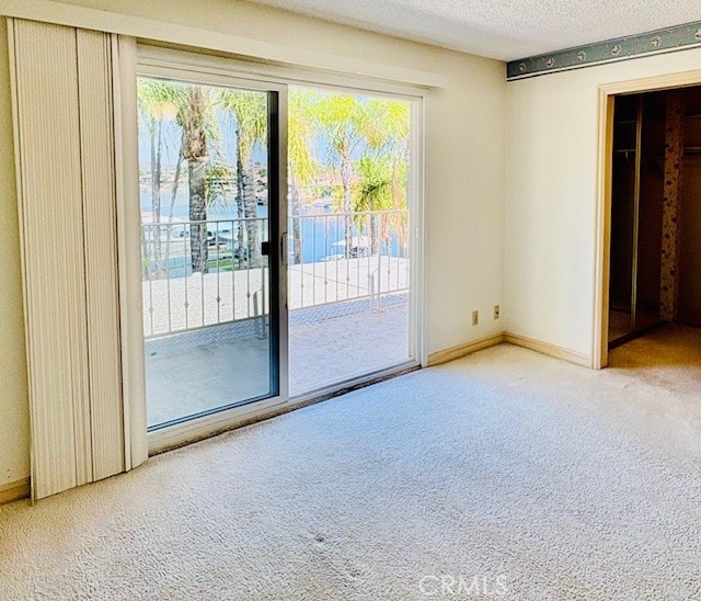 30417 Golden Gate Dr, Canyon Lake, CA 92587 - unfurnished bedroom with carpet, access to exterior, and a textured ceiling
