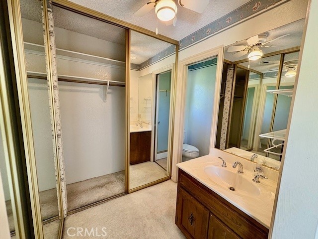 30417 Golden Gate Dr, Canyon Lake, CA 92587 - bathroom with a ceiling fan, vanity, a textured ceiling, and a walk in closet