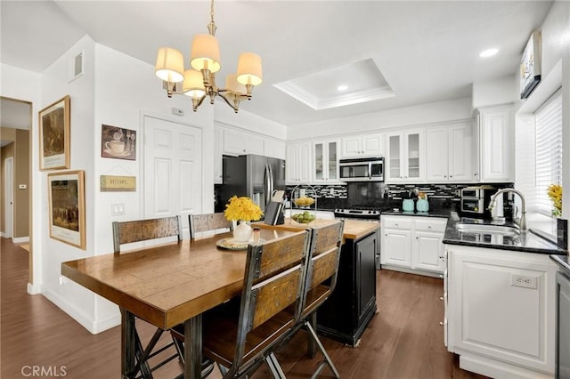23985 Nicole Way, Yorba Linda, CA 92887 - kitchen with appliances with stainless steel finishes, a sink, a chandelier, tasteful backsplash, and white cabinetry