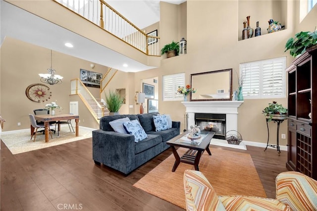 23985 Nicole Way, Yorba Linda, CA 92887 - living area featuring baseboards, a multi sided fireplace, dark wood finished floors, a chandelier, and a towering ceiling